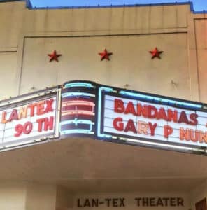 Lantex Theater with red stars on beige stucco facade and marquee with red letters